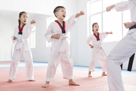 Young instructor teaching children Tae Kwon Do