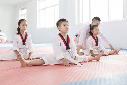 Young instructor teaching children Tae Kwon Do