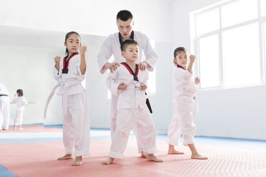 Young instructor teaching children Tae Kwon Do