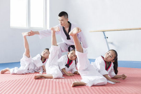Young instructor teaching children Tae Kwon Do