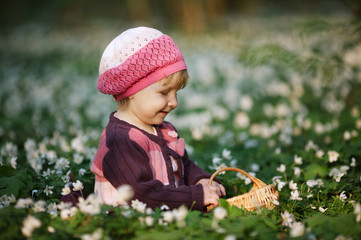 beautiful little girl in forest on flowers field