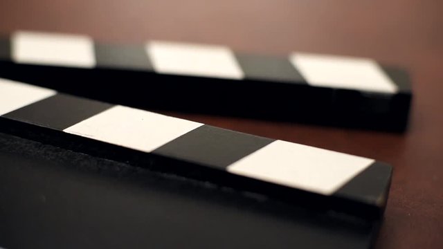 Movie clapper board part detail open and bumped on brown table background