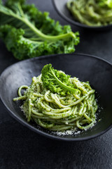 spaghetti pasta with  kale pesto sauce and parmesan cheese