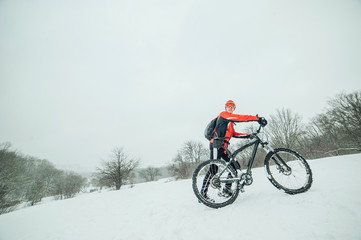 Extreme cyclist rides in the winter snowy forest