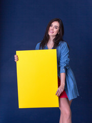 Happy woman holding a yellow blank sheet of paper