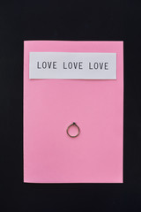 Engagement ring on pink paper
