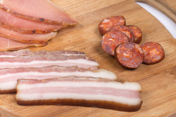 Sliced smoked bacon and sirloin on the wooden board