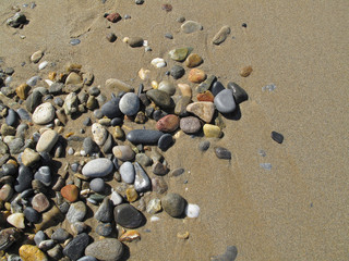Fototapeta na wymiar Sand background with sea pebbles