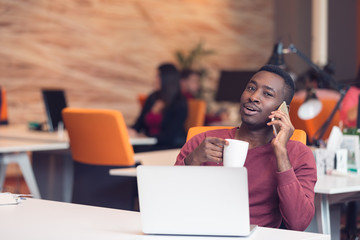 African American businessman sitting at the computer in his startup office