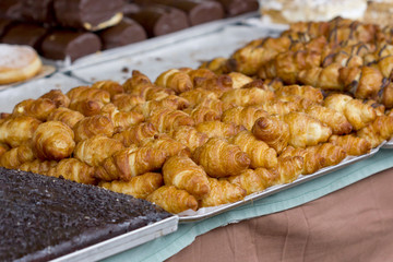 Tray full of croissants among other pastries products.