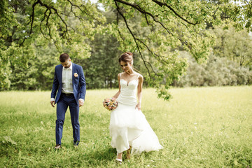 Young wedding couple enjoying romantic moments outside on a summer meadow