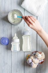 preparation of mixture baby feeding on wooden background top view