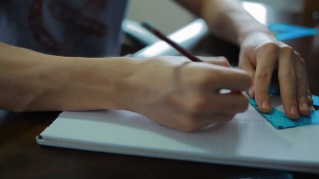 Teenage student doing his math homework at home