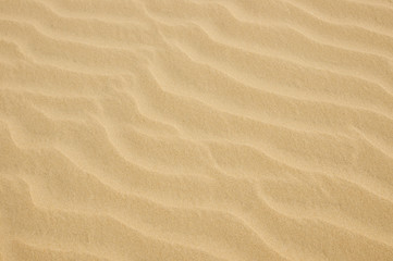 closeup of yellow sand pattern on a beach in the summer
