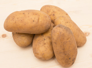 Fresh potatoes on a wooden background