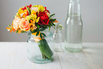 Red and yellow wedding bouquet with roses, tulips and lilies. 