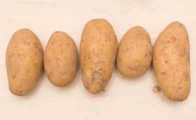 Fresh potatoes on a wooden background