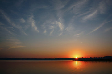 Fototapeta na wymiar Sunrise over the lake with clouds