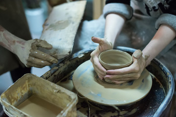 Hands working on pottery wheel