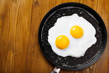 Delicious healthy simple breakfast meal made of eggs on a frying pan ready. Traditional homemade quick breakfast. International cuisine food. Top view.