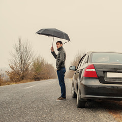 Businessman with an umbrella in the car
