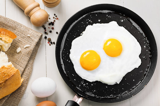 Fried eggs meal in a frying pan for delicious healthy breakfast. Traditional international breakfast food, top view.
