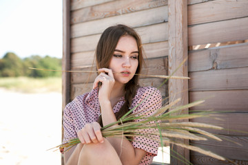 Young woman posing beside the wooden fence.
