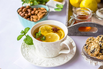 tea with lemon, honey, mint and spices on a white background