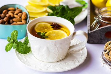 tea with lemon, honey, mint and spices on a white background