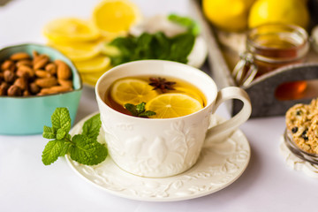 tea with lemon, honey, mint and spices on a white background