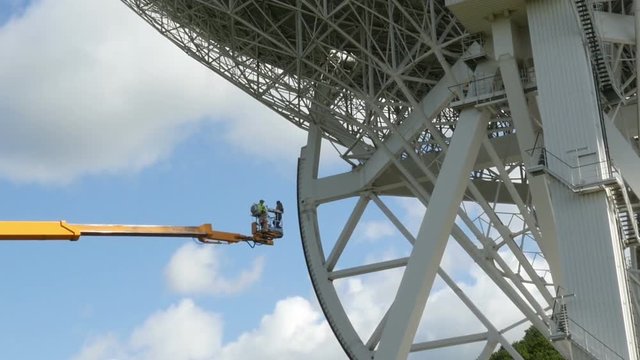 Workers on a crane renovate, painting the Effelsberg 100-m Radio Telescope zoom. 11818
