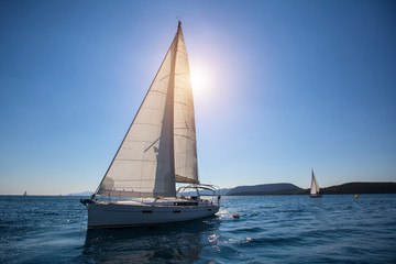 Obraz na płótnie Canvas Luxury yachts at regatta. Sailing in the wind through the waves at the Aegean Sea.