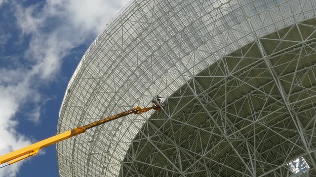 Workers on a crane renovate, painting the Effelsberg 100-m Radio Telescope zoom realtime. 11827
