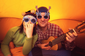 Man with woman in the funny glasses, playing ukulele