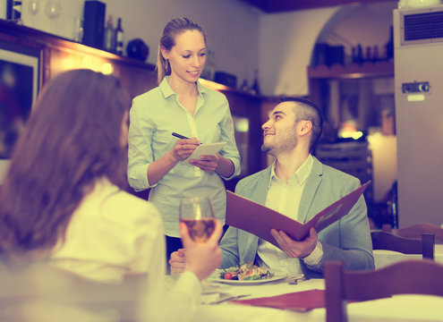 Waitress and guests in cafe .