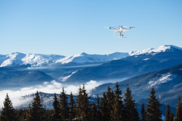 drone copter flying with digital camera over the mountains