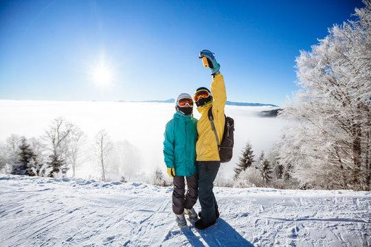 Skiers taking picture of themselves with smartphone over a mount