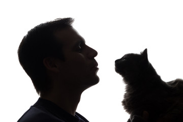 A young man with a kitten in his hands