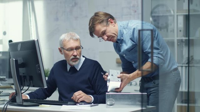  Two Senior Engineers Discuss Important Technical Component. Both are Experienced and Wise. Their Office Looks Modern and Bright. Shot on RED Cinema Camera in 4K (UHD). 