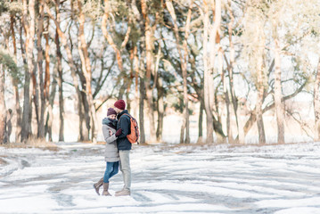 Fototapeta na wymiar Young hipster couple hugging each other in winter park.