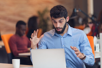 frustrated young business man working on desktop computer