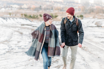 Young hipster couple hugging each other in winter park.