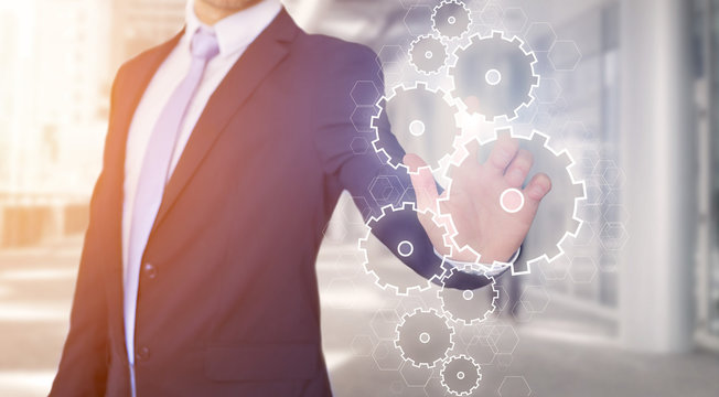 Businessman touching technology interface with gear wheel settin