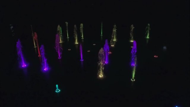 Fly by a colorful fountain at night