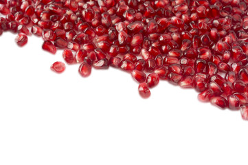 Background made of red pomegranate seeds. The scattered red grains of a pomegranate on a white background. Garnet with copy space for text. Top view.