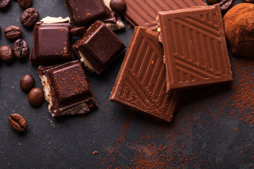 Delicious chocolates and spices on a black background.