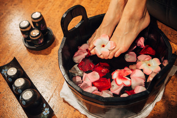 Young woman in foot-bath in oriental herb water for body detox