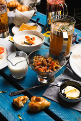 Breakfast on the table. Granola, porridge, croissant