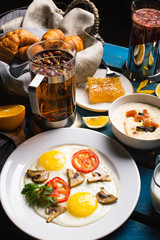 Breakfast on the table. Scrambled eggs with tomatoes and mushrooms.