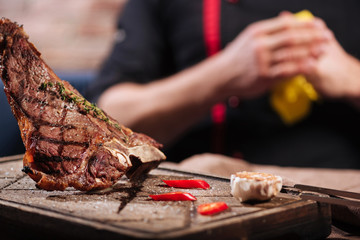 Close up of man posing with steak in restaurant.
